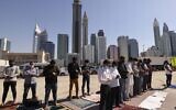 Muslim men perform Friday noon prayers close to their workplace on the first working Friday in the Gulf emirate of Dubai, on January 7, 2022. (Karim Sahib/AFP)