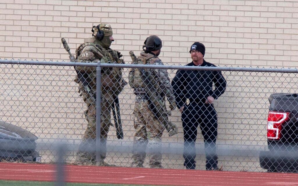 Law enforcement gathers at a local school near Congregation Beth Israel synagogue in Colleyville, Texas, January 15, 2022. (AP Photo/Gareth Patterson)