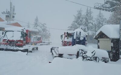 Snow covers bulldozers and emergency vehicles at the Hermon ski resort in the Golan Heights, January 26, 2022. (Hermon Ski Resort/Courtesy)