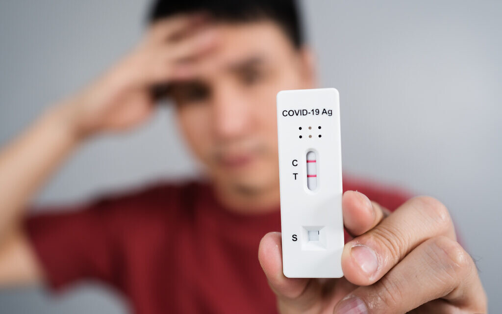 A young man who has just tested positive for the coronavirus holding his test kit (iStock via Getty Images)