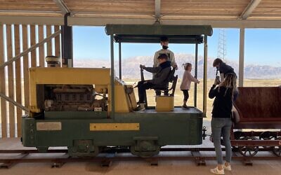 Young visitors enjoy clambering over an old engine at ICL's new Moshe Novomieski Visitors and Heritage Center at Sdom, southern Dead Sea, on January 20, 2022. (Sue Surkes/Times of Israel)