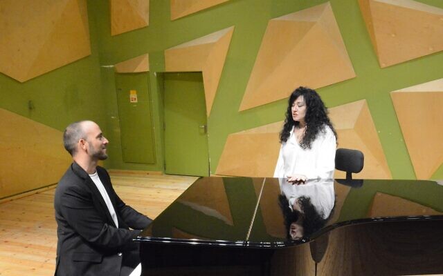 Composer and conductor Tomer Adaddi with singer Shlomit Aharon during their duet for 'Singing with the Composer,' Addadi's 2022 program that puts him at the front of the stage (Courtesy Tomer Addadi)