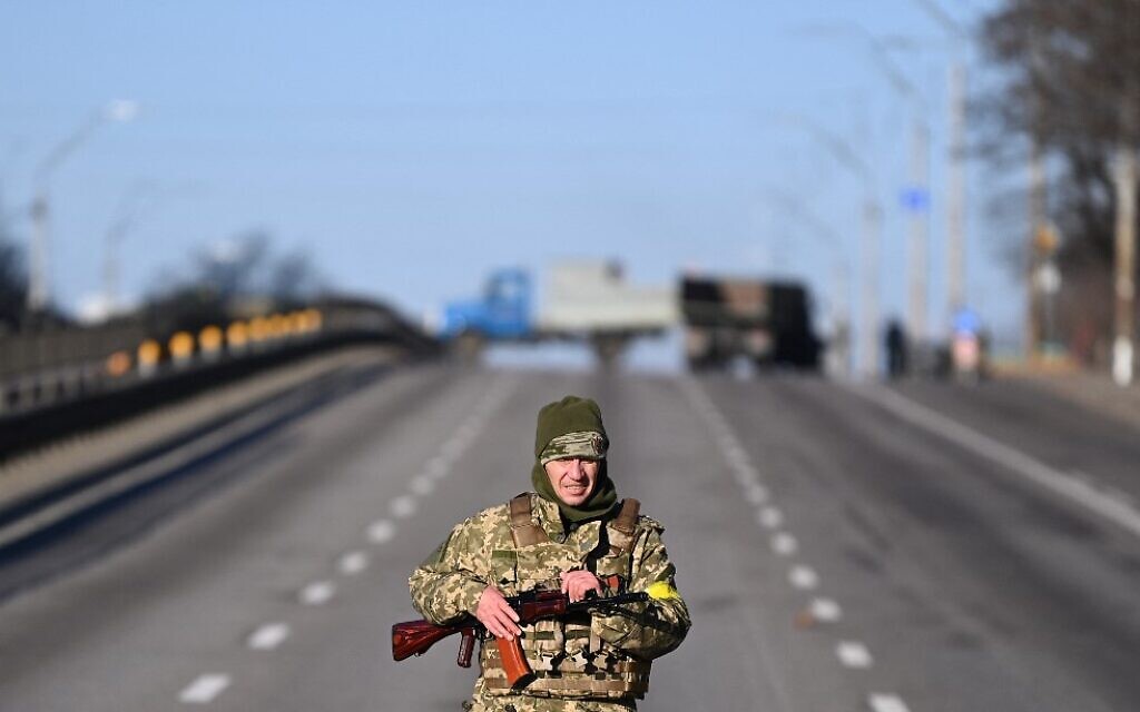 A Ukrainian service member patrols the empty road on the west side of the Ukrainian capital of Kyiv, in the morning of February 26, 2022.  (Daniel Leal/AFP)