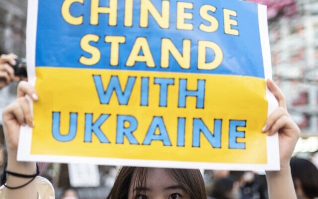 A woman holds a placard as people gather at Tokyo's Shibuya area to protest Russia's invasion of Ukraine, on February 27, 2022. (Charly TRIBALLEAU / AFP)