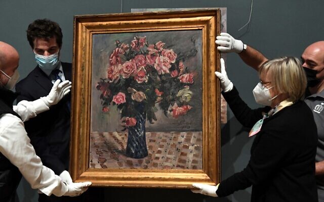 Belgian State Secretary for Scientific Policy, Recovery Program and Strategic Investments Thomas Dermine (left) and the lawyer of the Mayer family Imke Gielen (right) hold 'Blumenstilleben' ('Flowers'), at the Belgium Royal Museums of Fine-Arts in Brussels, on February 10, 2022. (John Thys/AFP)