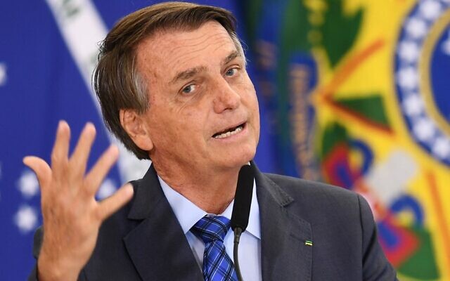 Brazilian President Jair Bolsonaro gestures as he speaks during a ceremony in which the salaries of teachers of elementary education were increased, at the Planalto Palace in Brasilia, on February 4, 2022. (Evaristo Sa/AFP)