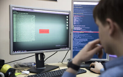 An employee of Global Cyber Security Company Group-IB develops a computer code in an office in Moscow, Russia, on Wednesday, October 25, 2017. (AP Photo/Pavel Golovkin)