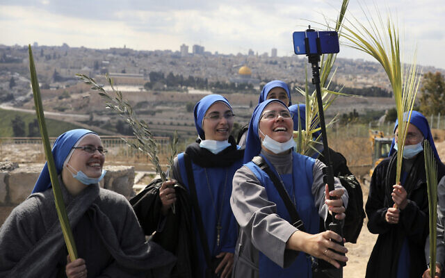 Nuns pose for a selfie as they mark Palm Sunday on the Mount of Olives in Jerusalem, Sunday, March 28, 2021. (AP Photo/Mahmoud Illean)