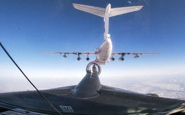 In this handout photo taken from video released by Russian Defense Ministry Press Service on Thursday, Jan. 27, 2022, a Russian Il-76 air tanker, top, is refueling a Russian Tu-95MS strategic bomber of the Russian Aerospace Forces during an aerial training in Russian Far East. (Russian Defense Ministry Press Service via AP)