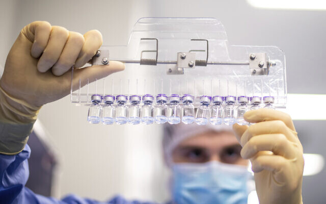 A technician inspects filled vials of the Pfizer-BioNTech COVID-19 vaccine at the company's facility in Puurs, Belgium in March 2021. (Pfizer via AP)