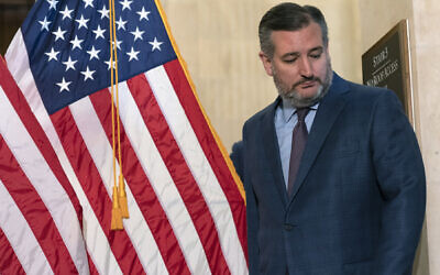Sen. Ted Cruz, R-Texas, walks past American flags, Tuesday, Feb., 1, 2022, after attending a weekly Republican policy luncheon on Capitol Hill in Washington. (AP Photo/Jacquelyn Martin)