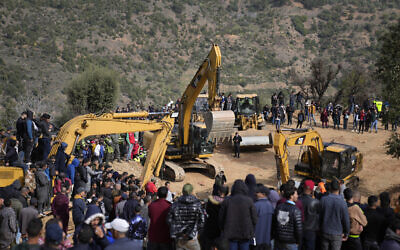 Residents watch civil defense workers and local authorities attempting to rescue a 5-year-old boy who fell into a hole near the town of Bab Berred near Chefchaouen, on February 4, 2022, in Ighrane. (AP Photo/Mosa'ab Elshamy)