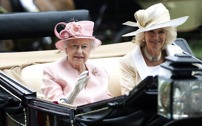 Britain's Queen Elizabeth II waves to the crowds with Camilla, Duchess of Cornwall, at right, as they arrive by carriage on the first day of the Royal Ascot horse race meeting in Ascot, England, June 18, 2013. (AP Photo/Alastair Grant, File)