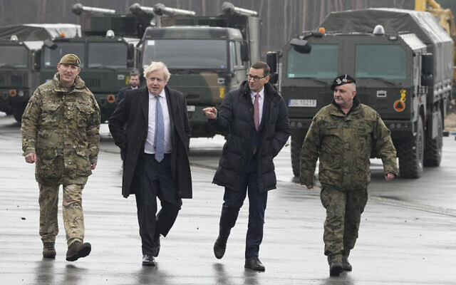 British Prime Minister Boris Johnson, center left, and his Polish counterpart Mateusz Morawiecki talk to British troops stationed in Poland on a NATO mission of enhancement of the alliance's eastern flank in Wesola, near Warsaw Poland, on Thursday, Feb. 10, 2022. (AP/Czarek Sokolowski)