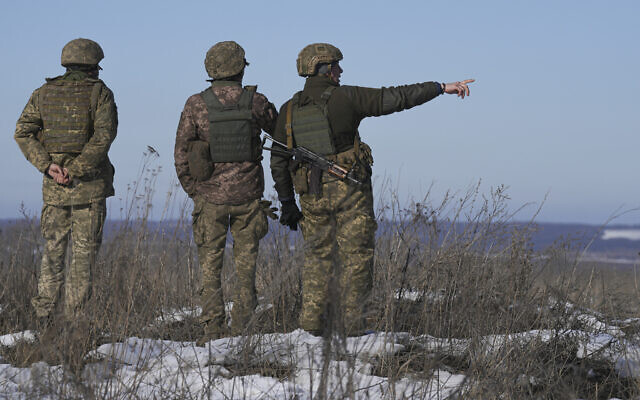 Ukrainian servicemen survey the impact areas from shells that landed close to their positions during the night on a front line outside Popasna, Luhansk region, eastern Ukraine, on February 14, 2022. (AP/Vadim Ghirda)