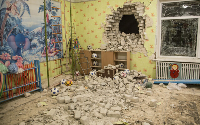 Bricks and debris mixes with toys below a damaged wall after the reported shelling on a kindergarten in the settlement of Stanytsia Luhanska, Ukraine on February 17, 2022. (AP Photo/Oleksandr Ratushniak)