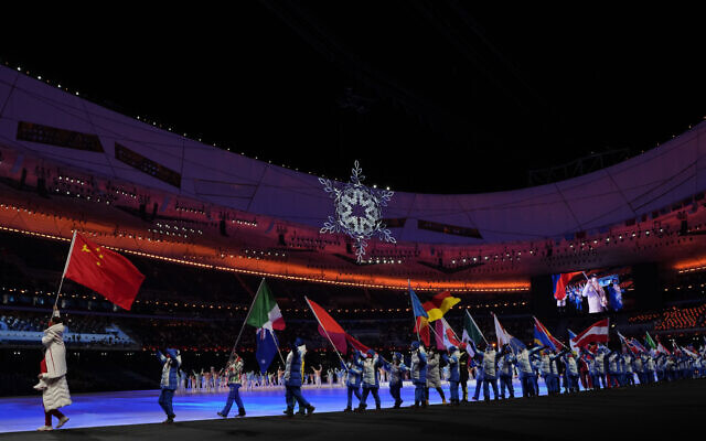 Flag bearers walk into the stadium for the closing ceremony of the 2022 Winter Olympics, Feb. 20, 2022, in Beijing. (AP Photo/Natacha Pisarenko)