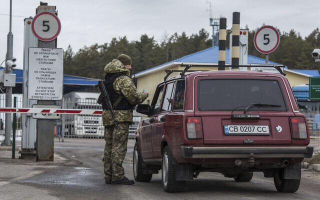 A Ukrainian border guard officer checks a car at the Ukrainian Belarusian state border checkpoint Novi Yarylovychi, Ukraine, Feb.21, 2022. (Oleksandr Ratushniak/AP)