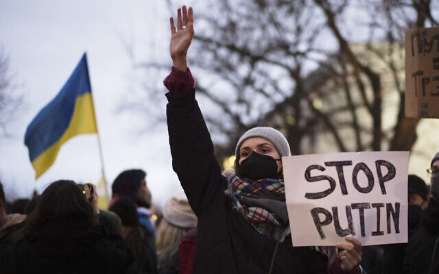 A woman shows a poster in support of Ukraine at a demonstration along the street near the Russian embassy to protest against the escalation of the tension between Russia and Ukraine in Berlin, Germany, on Tuesday, February 22, 2022. (AP Photo/Markus Schreiber)