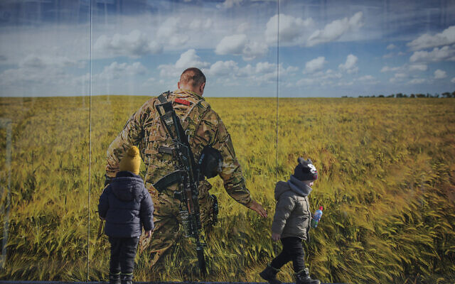 Children play by a large print at a photographic memorial for those killed in the confrontation between Ukraine’s military and the pro-Russia separatist forces in Sievierodonetsk, the Luhansk region, eastern Ukraine, Wednesday, Feb. 23, 2022. (AP/Vadim Ghirda)