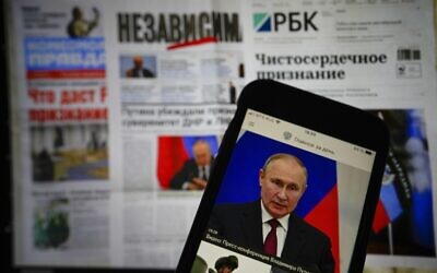 The app of the Russian government newspaper is displayed on an iPhone screen showing Russian President Vladimir Putin during his speech in the Kremlin in Moscow, Russia, on Tuesday, February 22, 2022. (AP Photo/Alexander Zemlianichenko Jr)