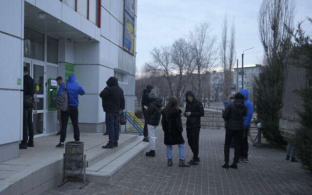 People line up to use an ATM machine outside in Sievierodonetsk, the Luhansk region, eastern Ukraine, Feb. 24, 2022 (Vadim Ghirda/AP)