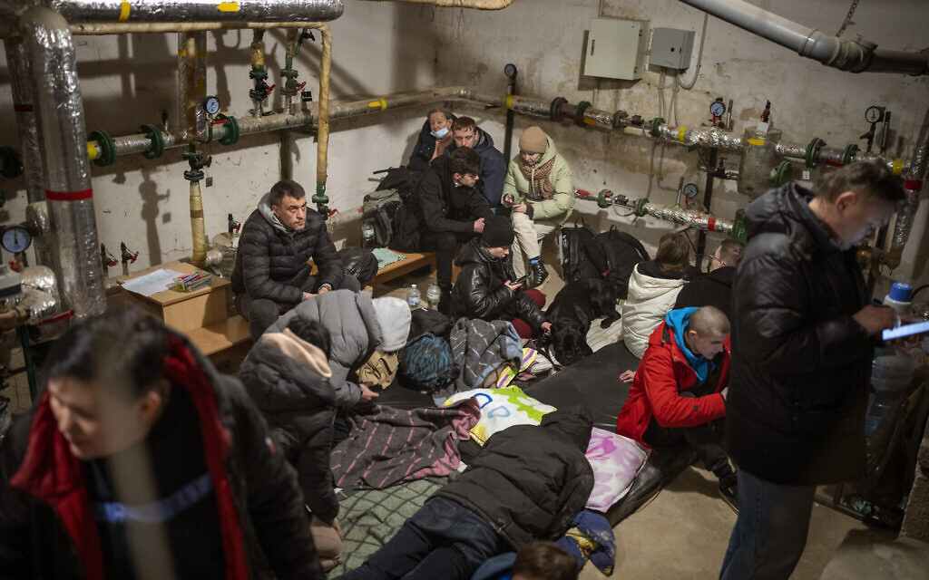 People take shelter at a building basement while the sirens sound announcing new attacks in the city of Kyiv, Ukraine, February 25, 2022. (AP/Emilio Morenatti)