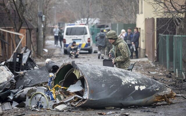 A Ukrainian Army soldier inspects fragments of a downed aircraft in Kyiv, Ukraine, February 25, 2022. (AP Photo/Vadim Zamirovsky)