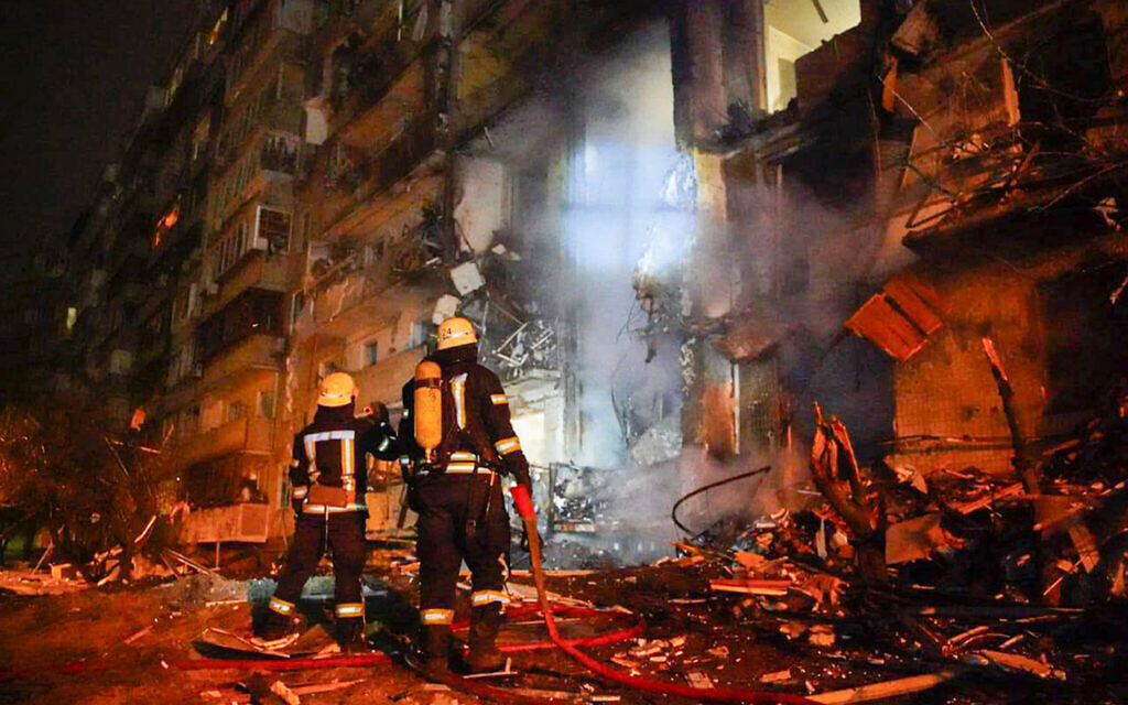 In this handout photo taken from video published by the Ukrainian Police Department Press Service on February 25, 2022, firefighters inspect the damage at a building following a rocket attack on the city of Kyiv, Ukraine (Ukrainian Police Department Press Service via AP)