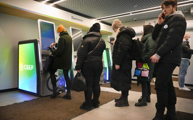 People stand in line to withdraw money from an ATM in Sberbank in St. Petersburg, Russia, Feb. 25, 2022 (AP Photo/Dmitri Lovetsky)