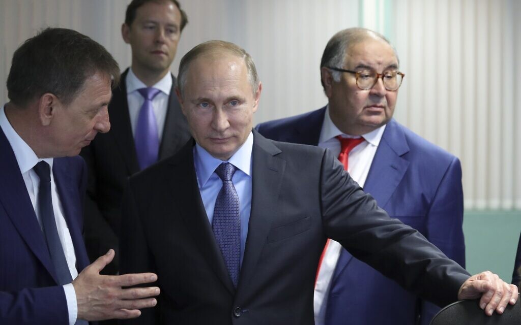 Russian President Vladimir Putin, center, listens to Lebedinsky GOK Managing Director Oleg Mikhailov, left, as businessman and founder of USM Holdings, Alisher Usmanov, right, and Minister of Industry and Trade Denis Manturov stand behind him while visiting the Lebedinsky GOK JSC, in Gubkin, Belgorod Region, Russia, Friday, July 14, 2017. Usmanov is not on the sanctions list implemented in response to the 2022 invasion of Ukraine. The metals tycoon was an early investor in Facebook. His fortune is estimated at more than $14 billion.  (Mikhail Klimentyev/Sputnik/Kremlin Pool Photo via AP, File)