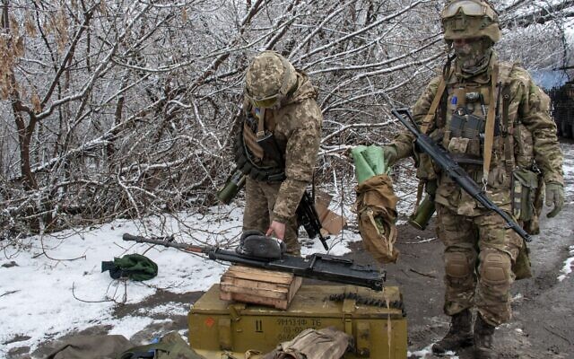 Ukrainian soldiers handle equipment outside Kharkiv, Ukraine, on February 26, 2022. (AP Photo/Andrew Marienko)