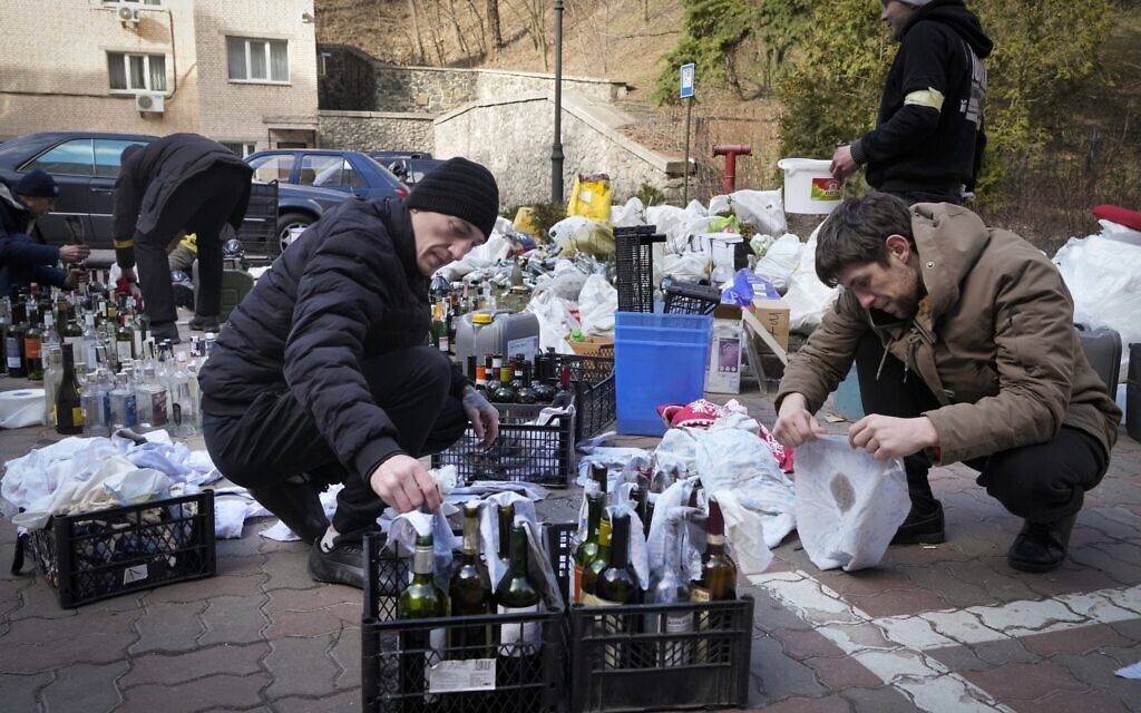 Members of civil defense prepare Molotov cocktails in a yard in Kyiv, Ukraine, Sunday, Feb. 27, 2022. (AP/Efrem Lukatsky)