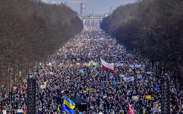 People walk down the bulevard 'Strasse des 17. Juni' ahead of a rally against Russia's invasion of Ukraine in Berlin, Germany, Sunday, Feb. 27, 2022. (AP Photo/Markus Schreiber)