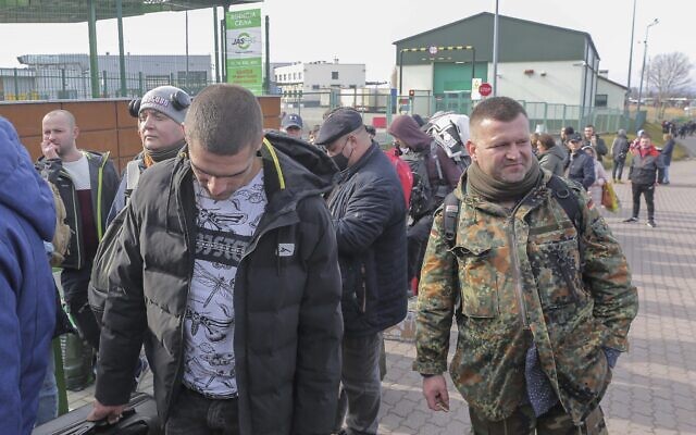 Polish volunteer Jedrzej, 34, in military uniform joins Ukrainians waiting to cross the border to go and fight against Russian forces, at Medyka border crossing, in Poland, on Saturday, February 26, 2022. (AP/Visar Kryeziu)