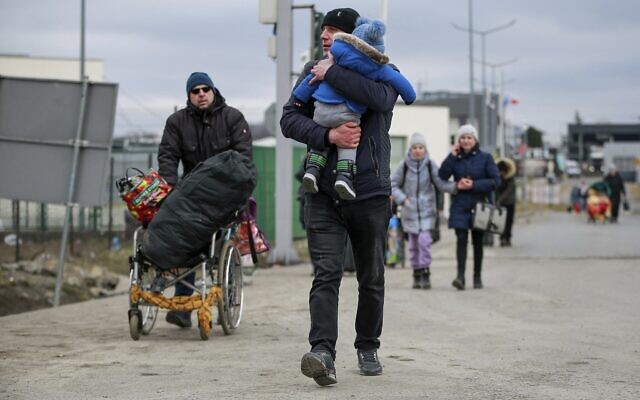 Refugees fleeing conflict in Ukraine arrive at the Medyka border crossing in Poland, on Monday, February 28, 2022. The head of the United Nations refugee agency says more than half a million people had fled Ukraine since Russia’s invasion on Thursday. (AP Photo/Visar Kryeziu)