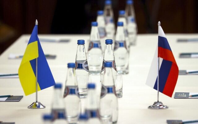Ukrainian and Russian national flags are placed on the table ahead of peace talks between Russian and Ukrainian delegations in a guest house in the Gomel region, Belarus, on Monday, February 28, 2022. (Sergei Kholodilin/BelTA Pool Photo via AP)