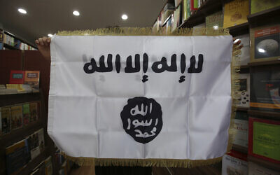 In this October 13, 2014 photo, a man shows an IS flag at an Islamic bookstore in the Fatih district of Istanbul. (AP Photo/Emrah Gurel)