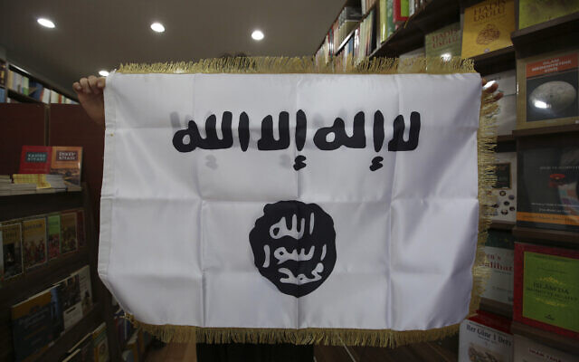 In this Oct. 13, 2014 photo, a man shows an IS flag at an Islamic bookstore in the Fatih district of Istanbul (AP Photo/Emrah Gurel)
