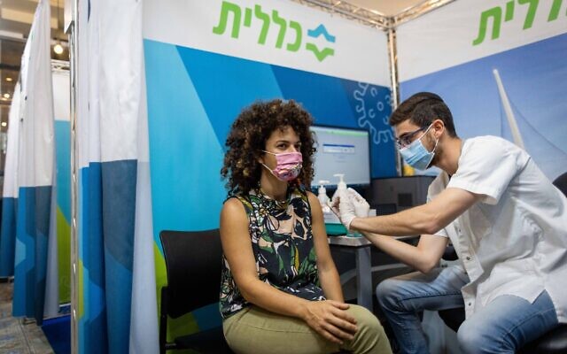 A woman receives a dose of the COVID-19 vaccine at a Clalit health care center in Jerusalem, on October 3, 2021. (Yonatan Sindel/Flash90)