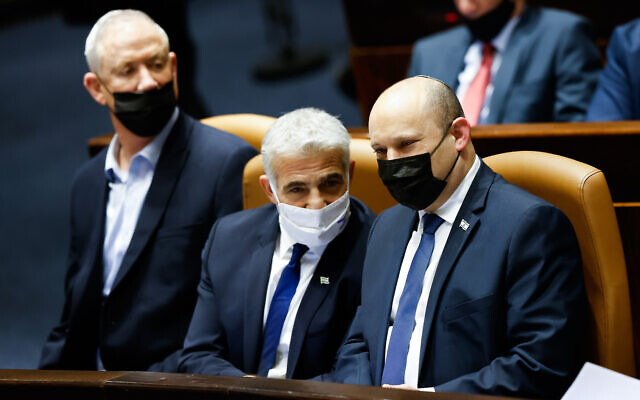 Defense Minister Benny Gantz (left), Foreign Minister Yair Lapid (center), and Prime Minister Naftali Bennett attend a plenum session in the Knesset, on January 31, 2022. (Olivier Fitoussi/Flash90)