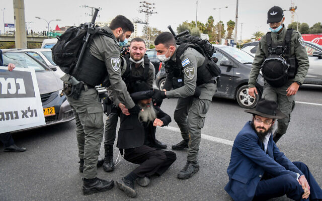 Ultra-Orthodox Jews clash with police as they protest against the ultra-Orthodox draft bill on Route 4 near Bnei Brak, February 9, 2022. (Flash90)