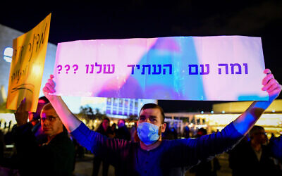 A protester at a demonstration against the high cost of living at Habima Square, in Tel Aviv, February 16, 2022. Poster read 'And what of our future???' (Avshalom Sassoni/Flash90)