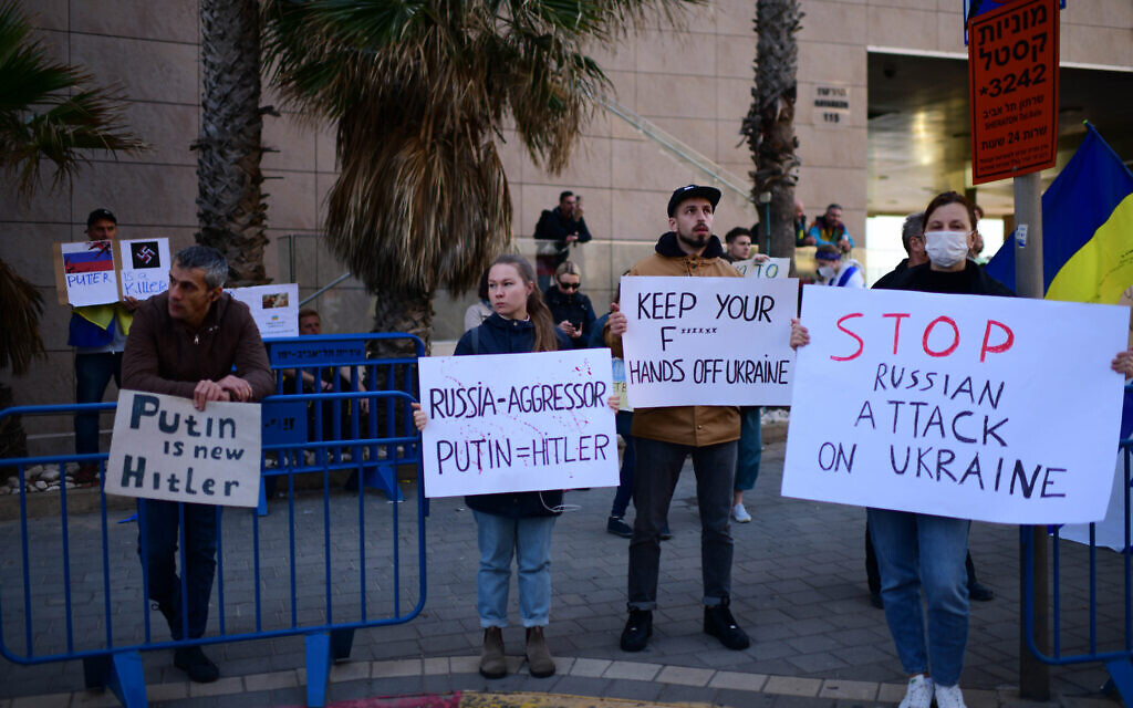 Demonstrators carry placards and flags during a protest against the Russian invasion of Ukraine, outside the Russian embassy in Tel Aviv, on February 24, 2022. (Tomer Neuberg/Flash90)