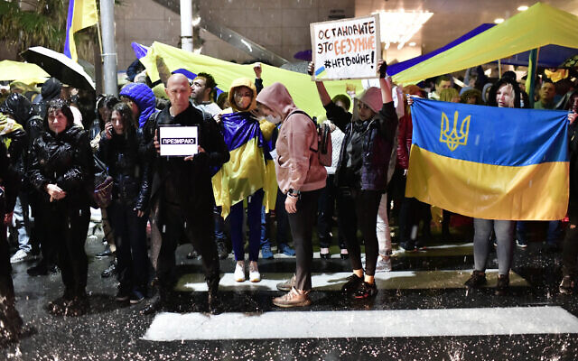 Demonstrators carry placards and flags during a protest against the Russian invasion of Ukraine, outside the Russian Embassy in Tel Aviv, on February 24, 2022. (Tomer Neuberg/Flash90)