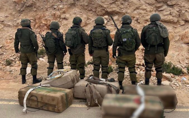 Troops stand next to drugs seized during a smuggling attempt on the Egypt border, on February 5, 2022. (IDF)
