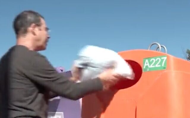 Screen capture from video of a man using an orange recycling bin. (Twitter)