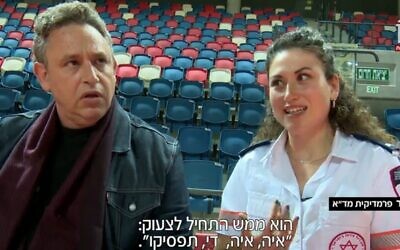 Screen capture from video of MDA paramedic Gal Trommer, left, meeting Ilan Weinstock, whose life she saved after he collapsed at a basketball match, February 2022. (Channel 12 News)