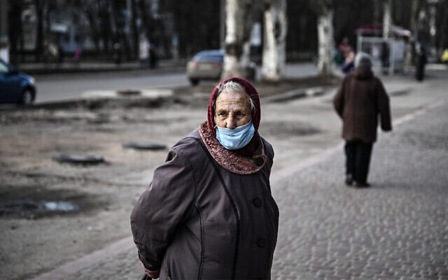 A woman stands in a street in the city of Avdiivka, eastern Ukraine, February 21, 2022. (Aris Messinis/AFP/File)