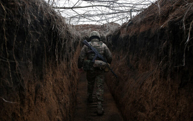 A Ukrainian soldier walks along trench on the frontline with Russia-backed separatists near Novolugansk in the Donetsk region of Ukraine, February 16, 2022. (Anatolii Stepanov/AFP)